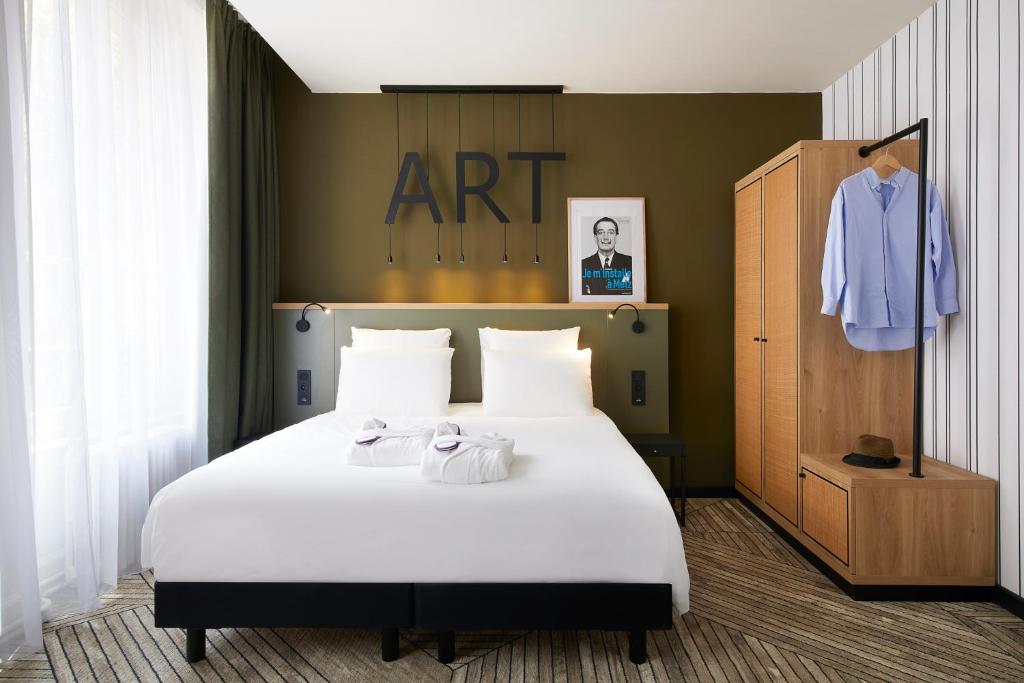 - une chambre avec un grand lit blanc et une commode dans l'établissement Mercure Grand Hôtel Metz Centre Cathédrale, à Metz