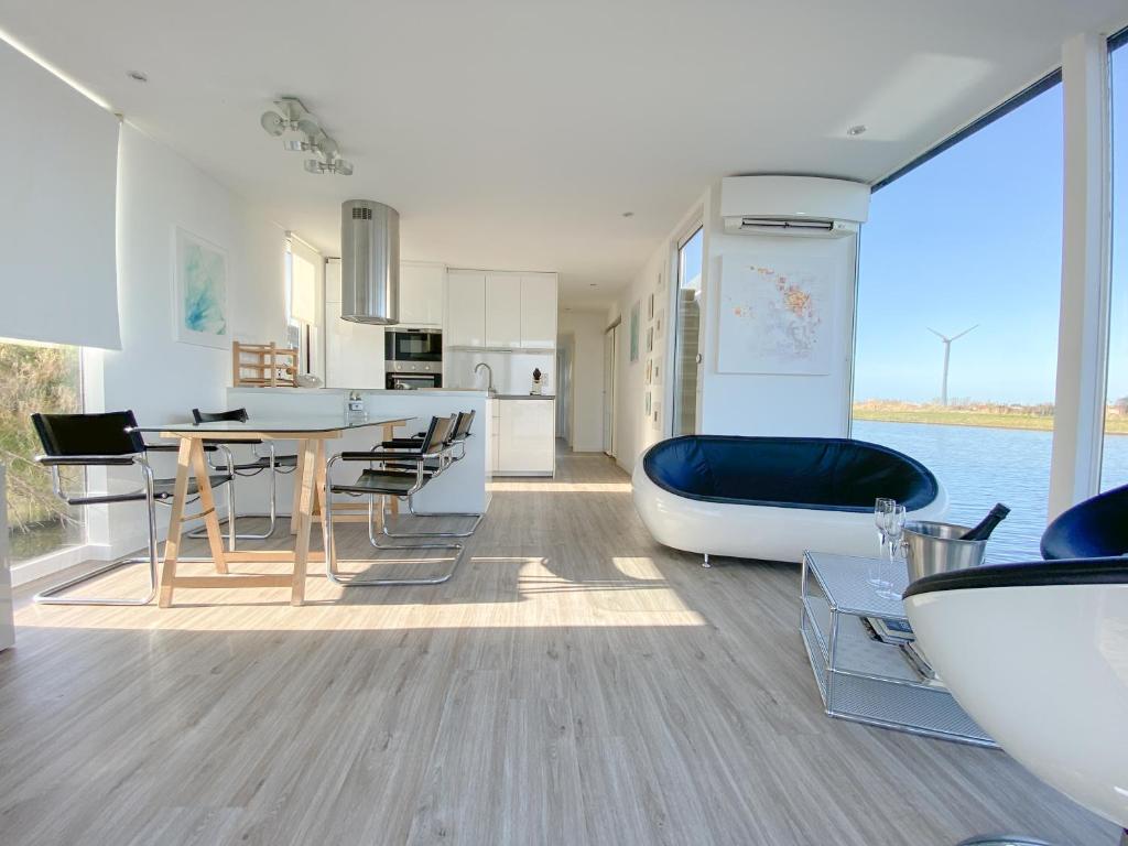 a kitchen and living room with a table and a tub at Homeboat Glamping in Nieuwpoort