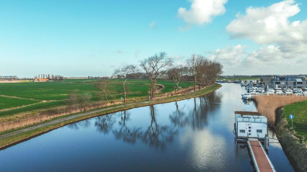 a view of a river with a boat on it at Homeboat Glamping in Nieuwpoort