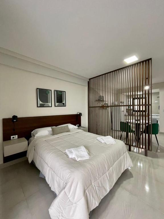 1 dormitorio con 1 cama blanca grande. en Altos de Argentina en San Miguel de Tucumán