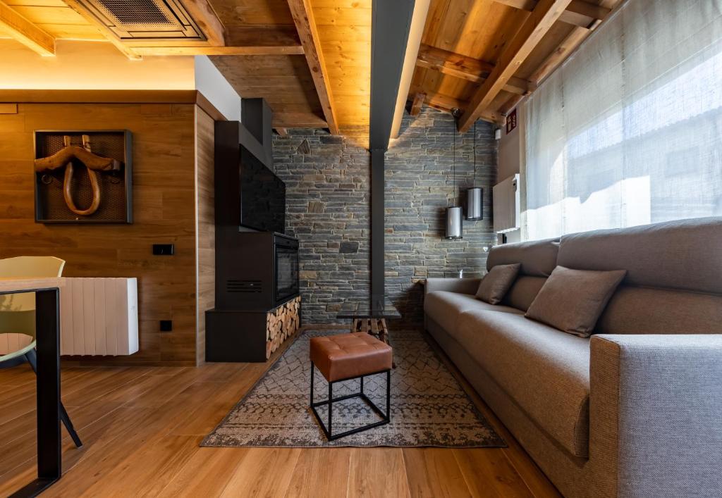 a living room with a couch and a brick wall at CERDANYA MOUNTAIN RESIDENCES in Bellver de Cerdanya