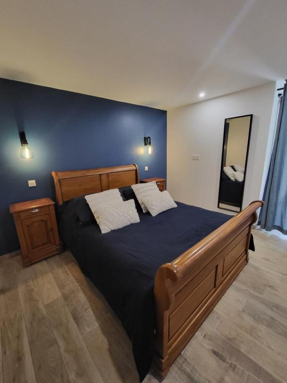 a bedroom with a large bed with a blue wall at Les gîtes de ninon in Moult