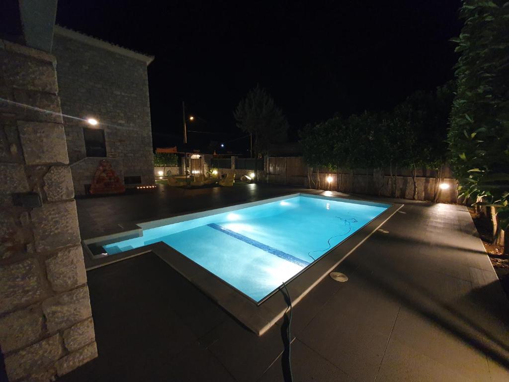 una piscina en un patio trasero por la noche en Villa Lina Salamina en Ambelákia