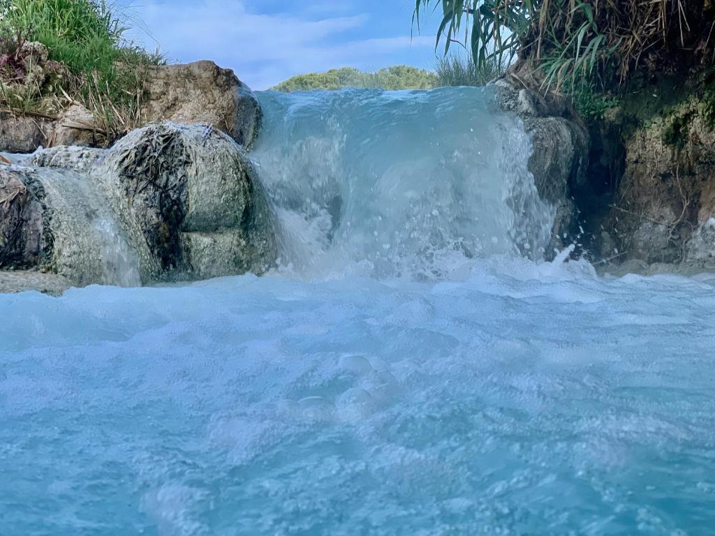 a waterfall on the side of a river at Casale Terre Rosse in Saturnia