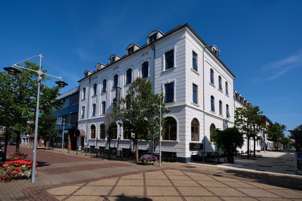 ein großes weißes Gebäude in einer Stadtstraße in der Unterkunft Hotel Phønix Brønderslev in Brønderslev