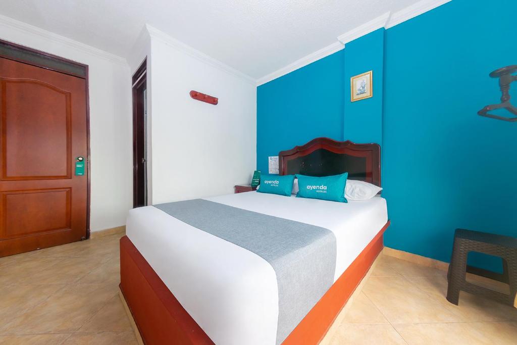 una camera da letto con un grande letto con pareti blu di Ayenda La Terraza Popayán a Popayan