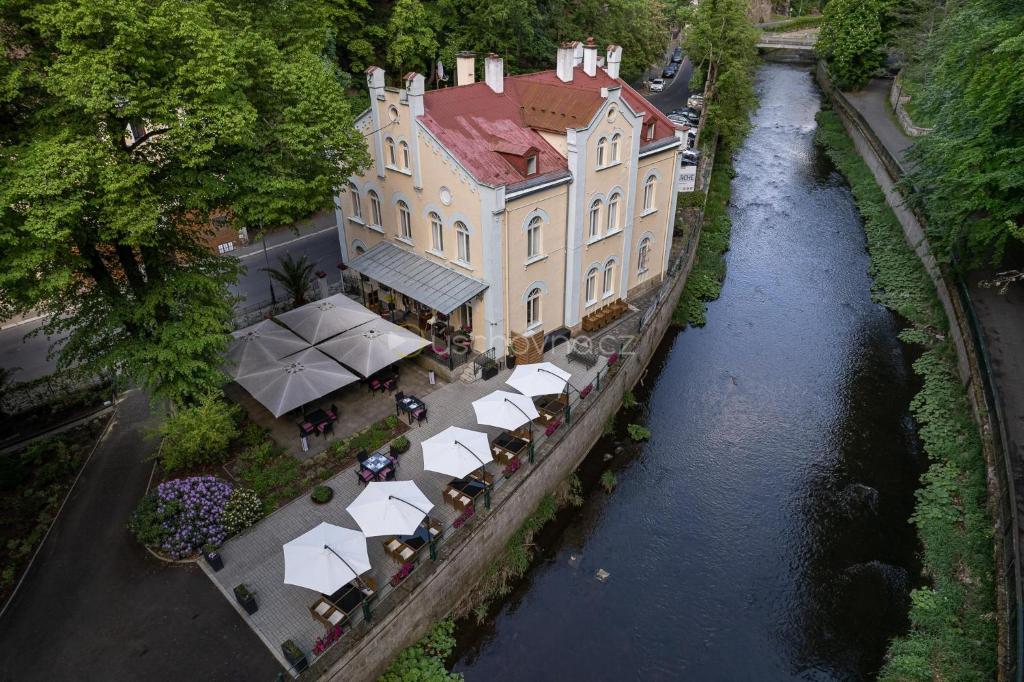 eine Luftansicht eines Gebäudes neben einem Fluss in der Unterkunft Villa Basileia Riverside in Karlsbad