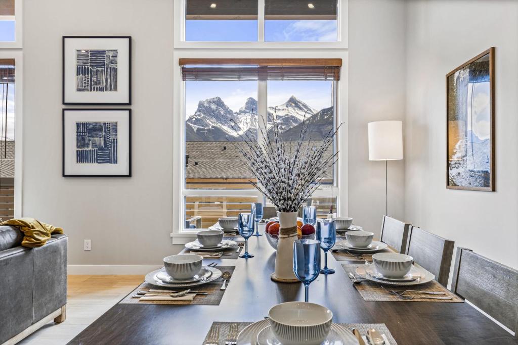 a dining room with a table and a view of a mountain at BRAND NEW - Gorgeous Spring Creek Penthouse in Canmore