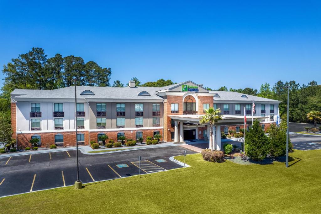 eine Luftansicht eines Hotels mit Parkplatz in der Unterkunft Holiday Inn Express Hotel & Suites Hinesville, an IHG Hotel in Hinesville