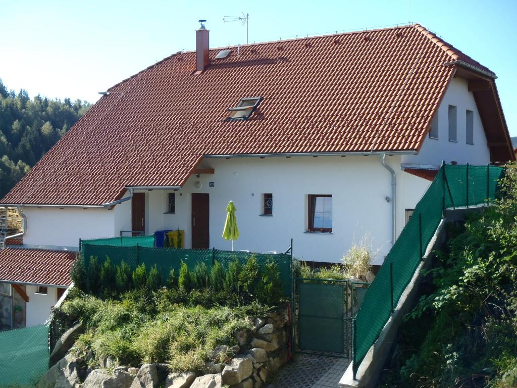 a white house with a red roof at Apartmány Fialka in Kašperské Hory