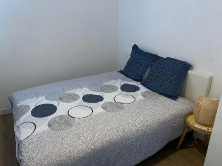 a bedroom with a bed with blue and gray pillows at Belle Isle in Châteauroux