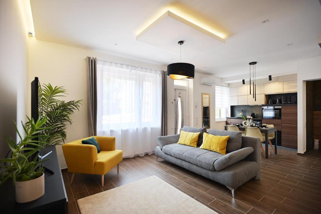 a living room with a couch and a yellow chair at ZÓRA APARTMAN in Eger
