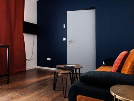a living room with a couch and a blue wall at Belle Isle in Châteauroux