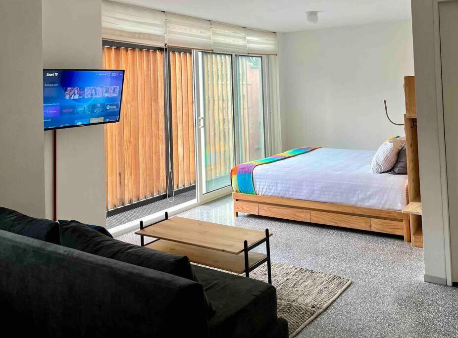 sala de estar con cama y TV de pantalla plana en D 111 Beautiful & confortable loft centro CDMX, en Ciudad de México