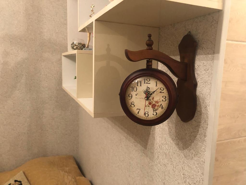 a clock hanging on a wall in a room at Guesthouse BATU in Kutaisi