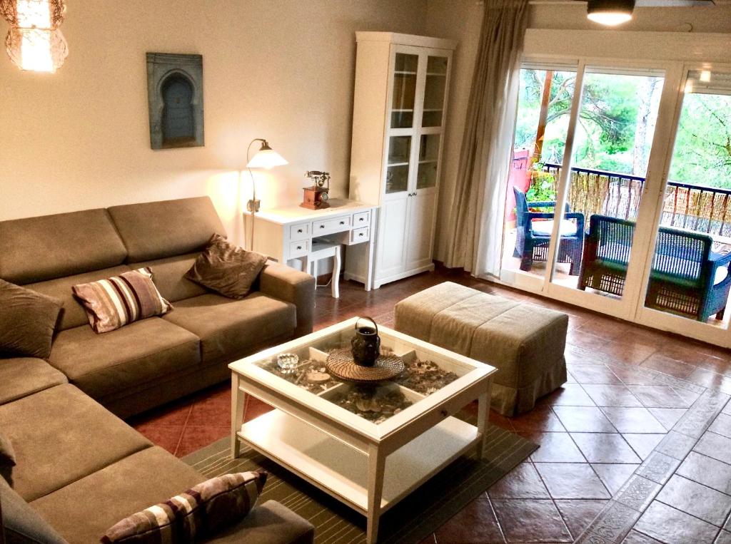 uma sala de estar com um sofá e uma mesa de centro em La casa del pantano de San Juan em San Martín de Valdeiglesias