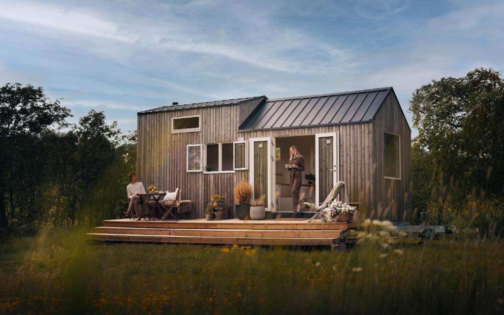 a woman standing on the porch of a tiny house at Camp Saltstraumen-Elvegård in Bodø