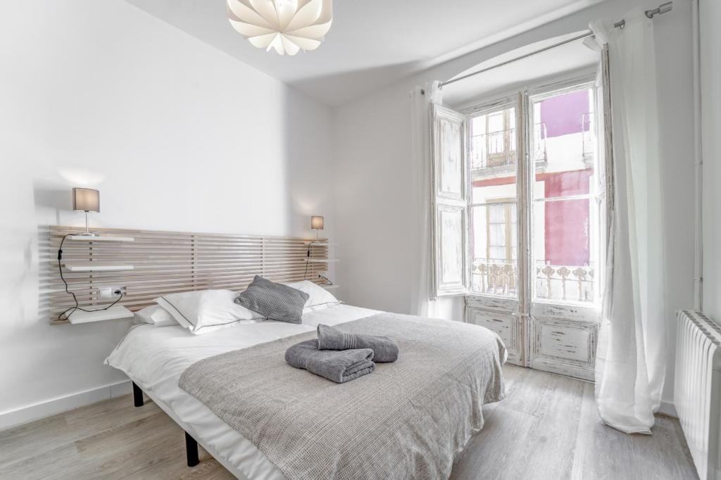 a white bedroom with a bed with two pillows on it at 3.2 Apartamento Coma Oriola in Puigcerdà