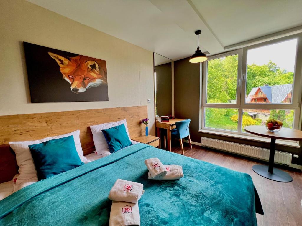 a bedroom with a large bed with blue sheets at Apartament 26 Resort Kozubnik blisko Szczyrk - 5D Apartamenty in Porąbka
