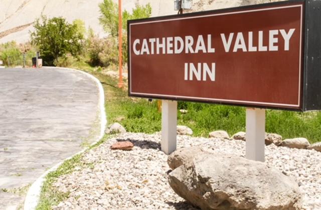 una señal para una posada carificial Valley en una carretera en Cathedral Valley Inn, en Caineville