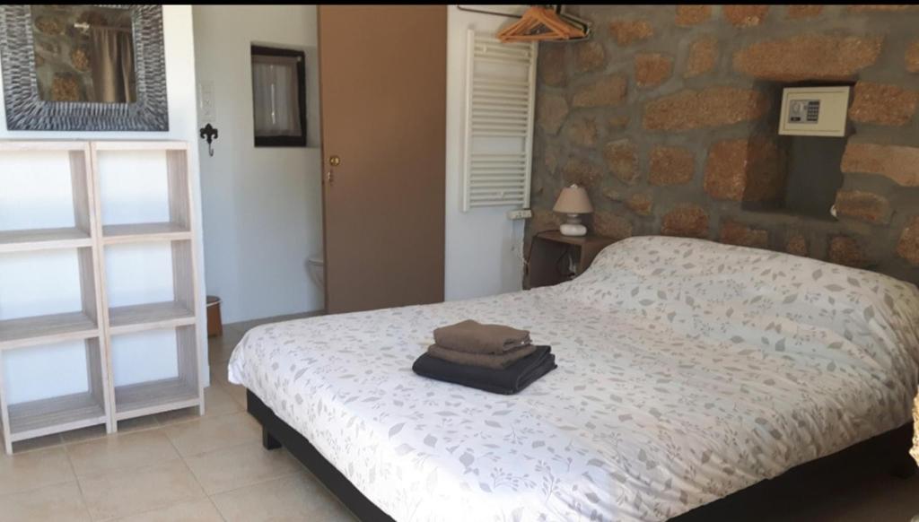 - une chambre avec un lit et un sac dans l'établissement Chez Robert et Sylvie, à Pianottoli-Caldarello