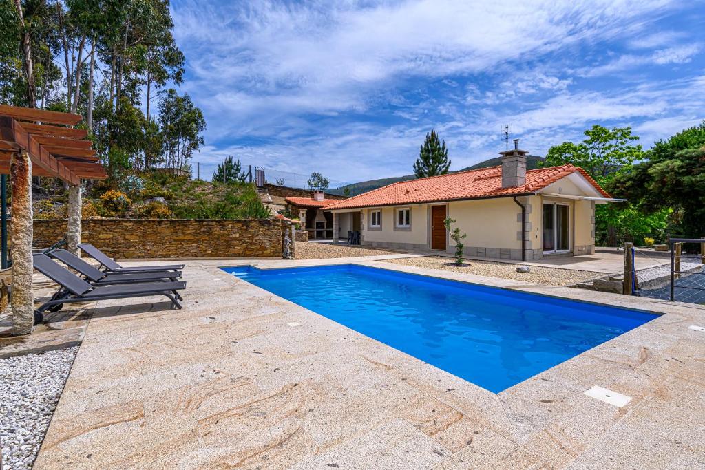 a villa with a swimming pool in front of a house at Escolinha de France in France