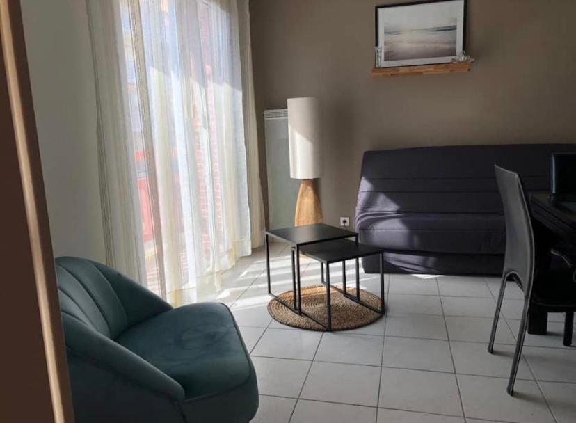 un salon avec un canapé, une table et une chaise dans l'établissement Appartement de standing au port de l’Aiguillon, à Arcachon