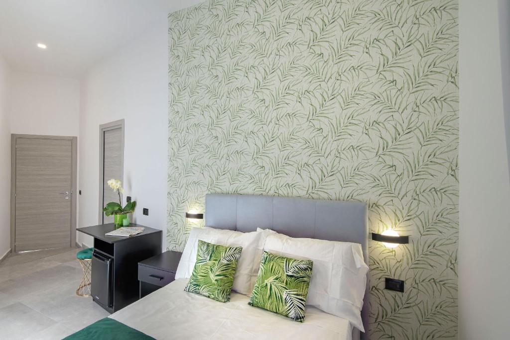 a bedroom with a bed with a green and white wall at Red Queen Naples in Naples
