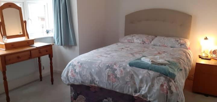 1 dormitorio con 1 cama con tocador y espejo en Beautiful En-suite room, en Wokingham