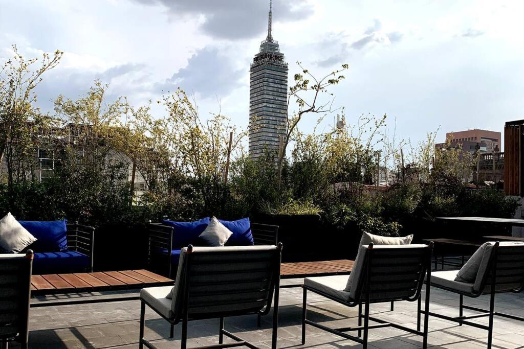 un patio con sillas, una mesa y un edificio en 117 SUITES DONCELES CENTRO HISTÓRICO CDMX, en Ciudad de México