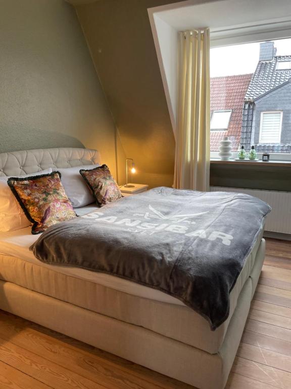 - un grand lit dans une chambre avec fenêtre dans l'établissement Schöne große 4 Zimmer-Altbauwohnung, à Kiel