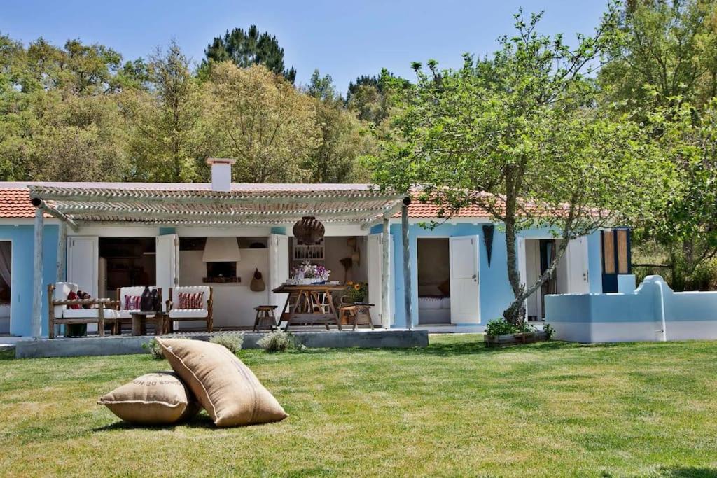 a house with two pillows sitting in the grass at Casa de Cantoneiros, Comporta in Torroal