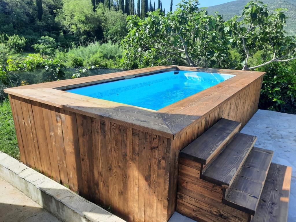 a wooden hot tub with a bench around it at Private Countryside House Three Figs in Gruda