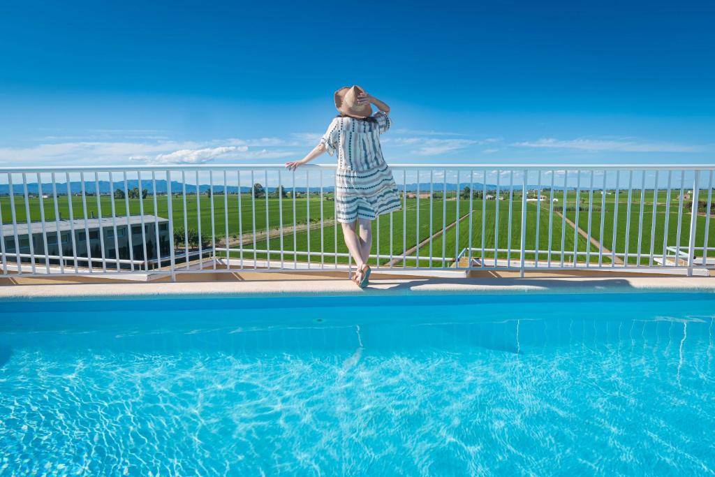 Un uomo sta saltando in una piscina di El Rincón de Elena Delta del Ebro a Els Muntells