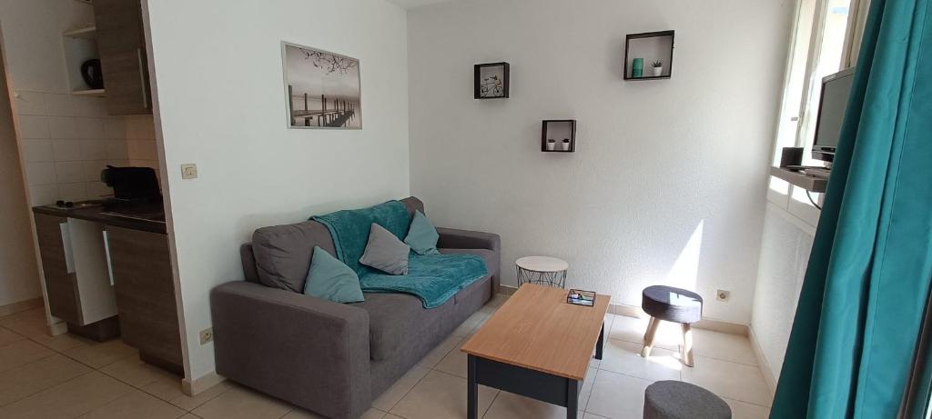un salon avec un canapé et une table dans l'établissement Beau STUDIO de 27m au centre de FREJUS !, à Fréjus