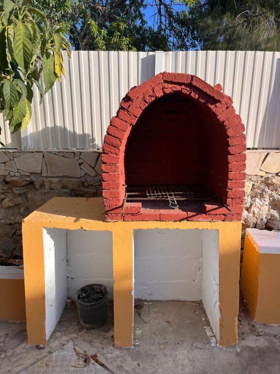 un horno de pizza de ladrillo sentado en la parte superior de un banco en Casa Amarela en Loulé