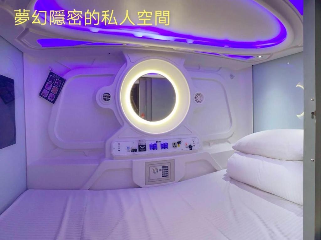a white toilet in a room with white walls at Hey Bear Capsule Hotel in Taipei