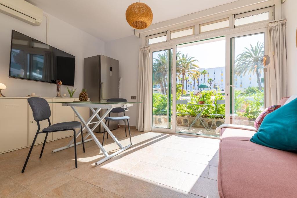 a living room with a couch and a table with chairs at Quality and peaceful stay in Playa del Inglés in Playa del Ingles
