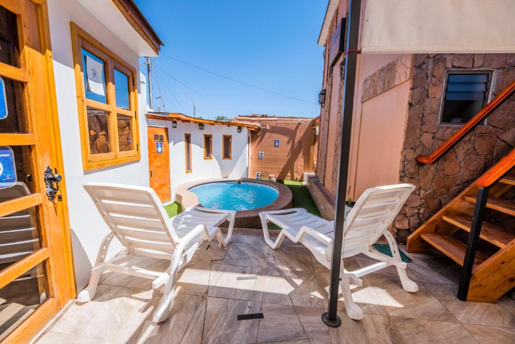 a patio with two chairs and a swimming pool at Hotel Parina Atacama in San Pedro de Atacama