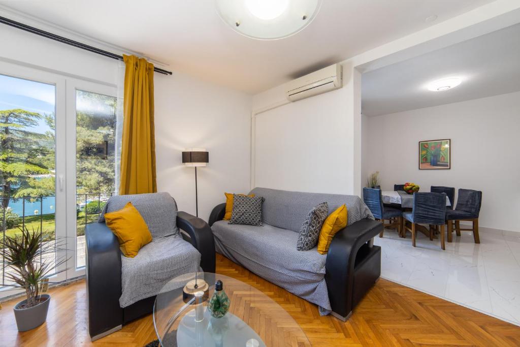 a living room with two couches and a table at Apartman Porto in Ploče