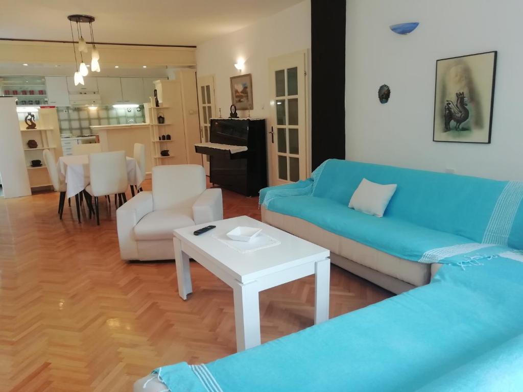 a living room with a blue couch and a table at Pine Apartment in Gevgelija