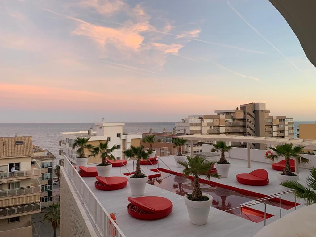 einen Balkon mit roten Stühlen und Meerblick in der Unterkunft Bonito apartamento Carvajal - Fuengirola - The Wave in Fuengirola