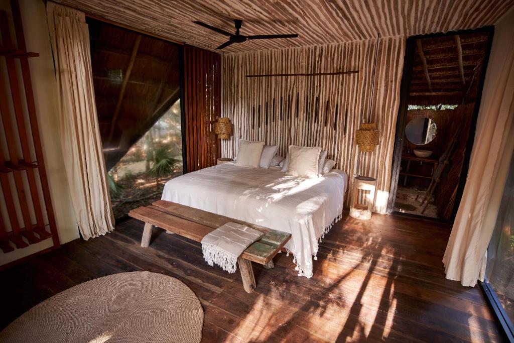 a bedroom with a bed and a table in it at Kapok Bacalar - Plant Based Hotel in Buenavista