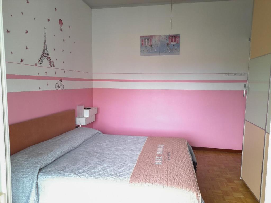 1 dormitorio con 1 cama con pared de color rosa en BIKE HOUSE 1 "silver" en Seriate