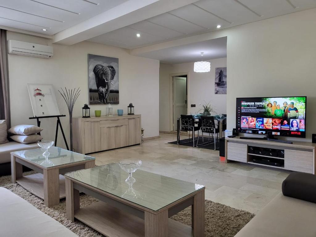 a living room with a couch and a tv at Luxury Spacious Apartment Midtown Casablanca in Casablanca