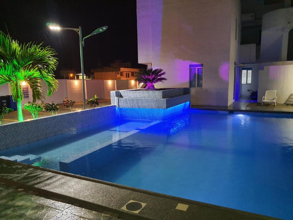 una piscina por la noche con luces azules en Departamento amoblado en Tonsupa, en Tonsupa