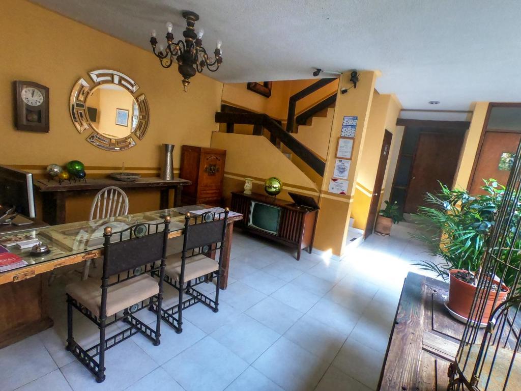 ein Wohnzimmer mit einem Tisch, Stühlen und einer Treppe in der Unterkunft Posada del Carmen in Zacatecas