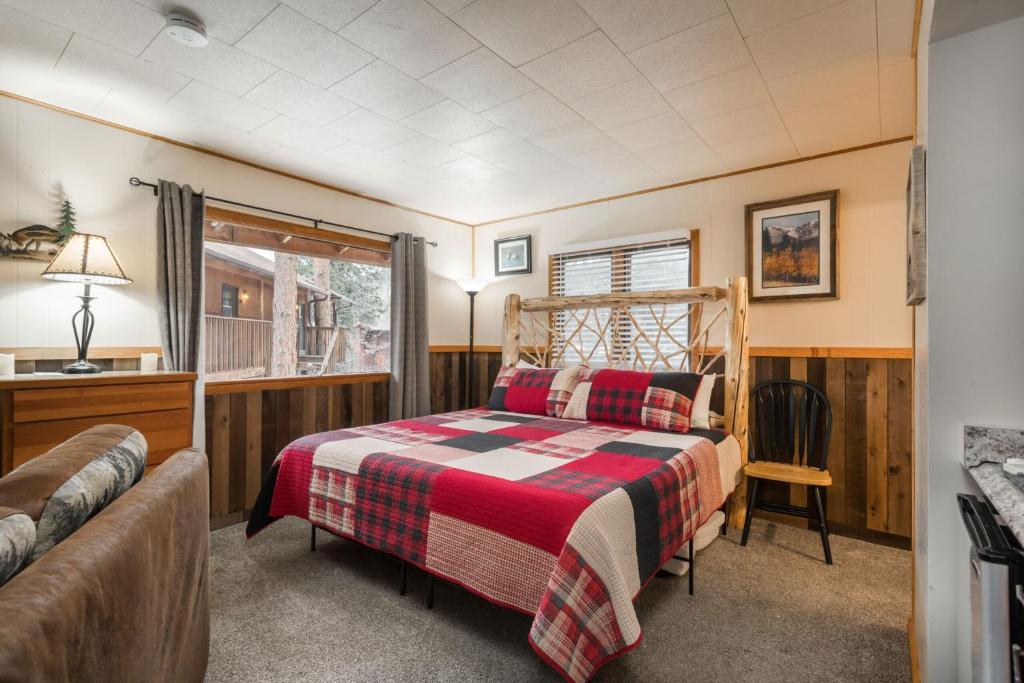 een slaapkamer met een bed en een raam bij Ponderosa Lodge in Estes Park