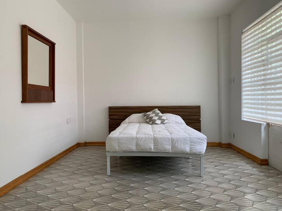 een slaapkamer met een bed in een kamer met een raam bij 1C TU CASA CENTRO CDMX CONFORTABLE in Mexico-Stad