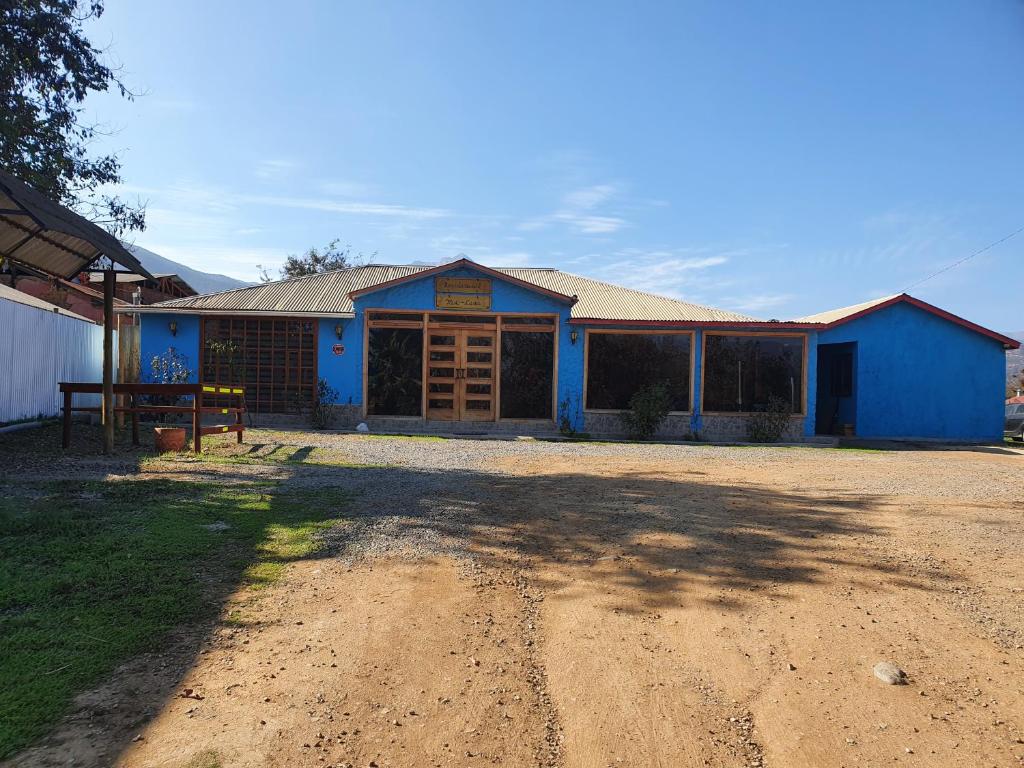 un edificio azul con un camino de tierra delante de él en Residencial mi Casa, en Olmué